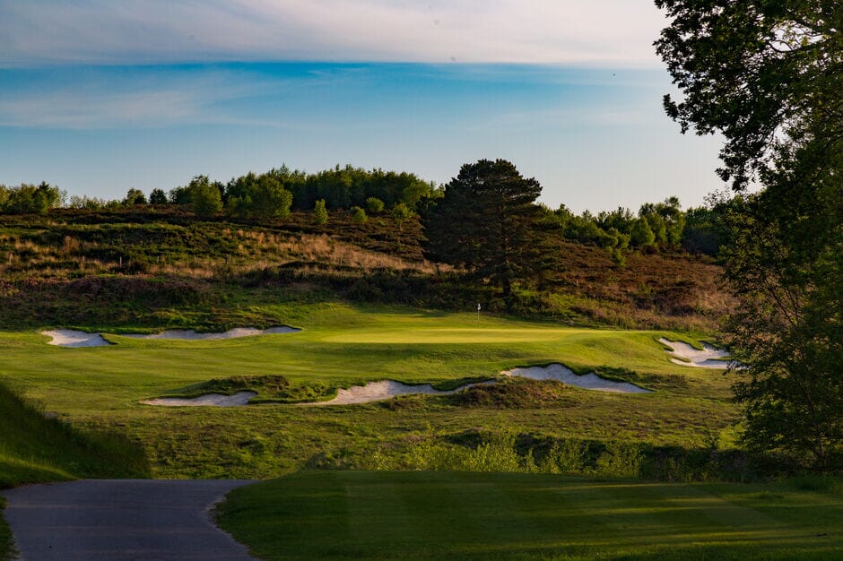 Broadstone Golf Club heathland green with bunkers and mature trees