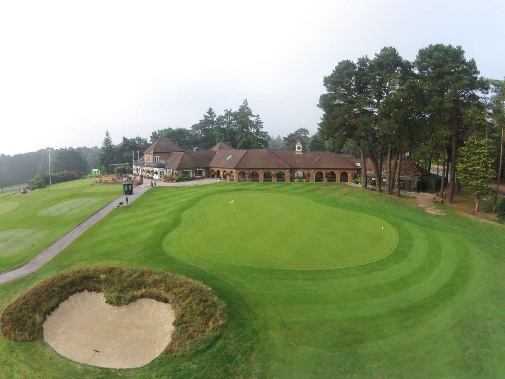 Ferndown Golf Club heathland course with green, bunkers and clubhouse