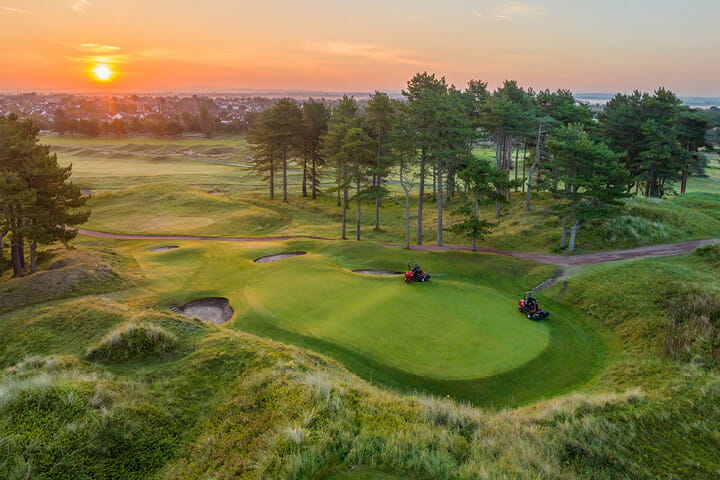 Hillside Golf Club links course at sunset with dunes, pines and a green